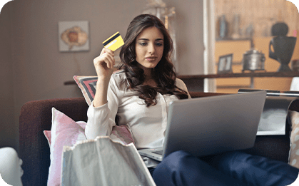 Young woman shopping online with laptop and credit card at home